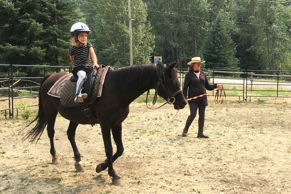 image of little girl getting a riding lesson